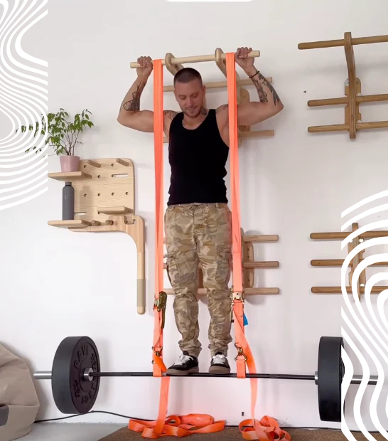 Test obciążenia drewnianego drążka Fit Your Gym: mężczyzna stoi na sztandze podwieszonej pasami do drążka